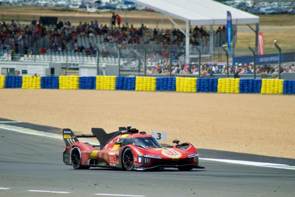 Red Ferrari endurance Hypercar competing at the Circuit de la Sarthe during the 24 Hours of Le Mans.